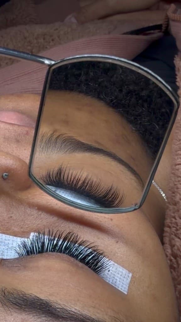 Lash extension application reflected in mirror during service