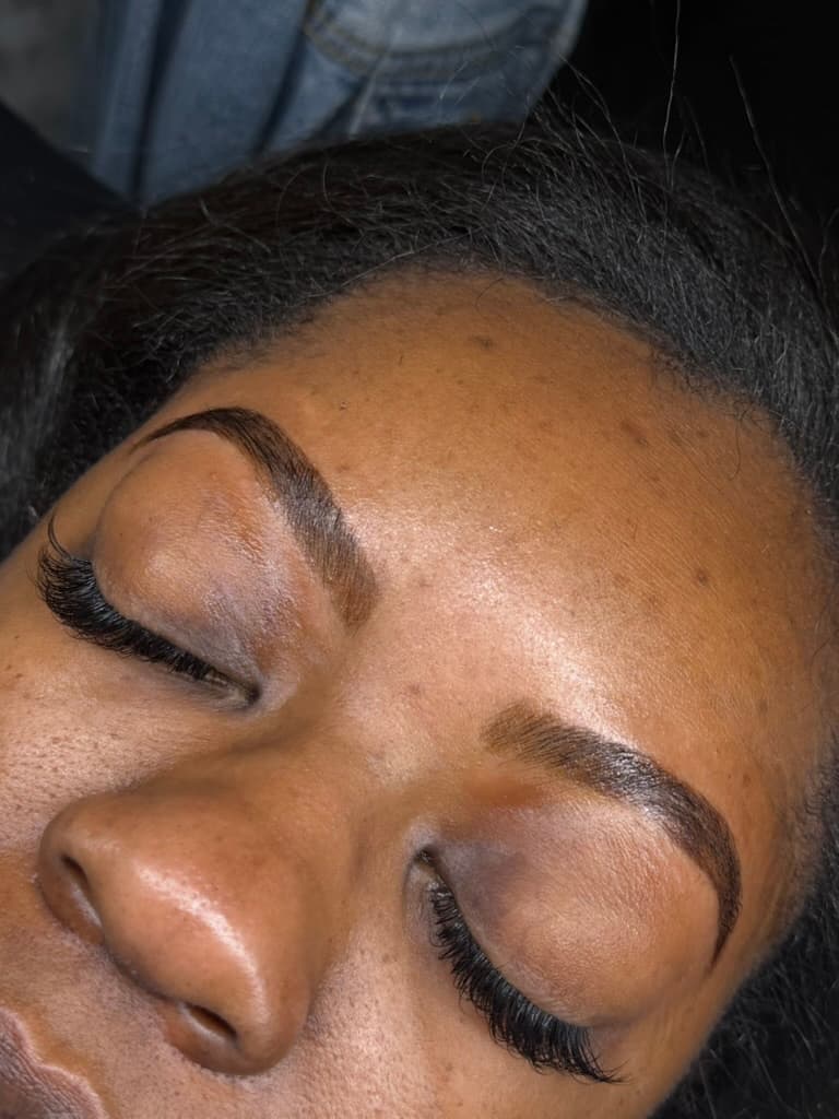 Close-up of voluminous lash extensions and defined tinted brows at Total Esthetics